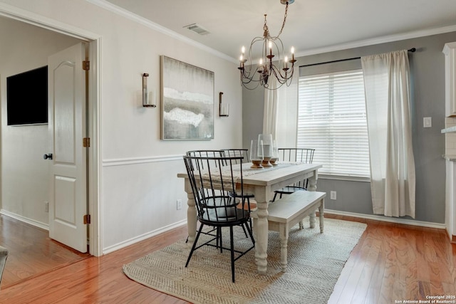 6039 Woodway Ct, San Antonio, TX 78249 - dining room featuring wood finished floors, a chandelier, crown molding, and baseboards