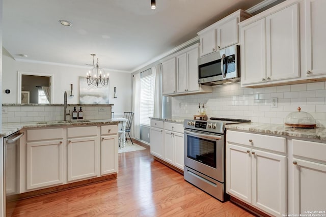 6039 Woodway Ct, San Antonio, TX 78249 - kitchen featuring appliances with stainless steel finishes, a sink, tasteful backsplash, a chandelier, and white cabinets