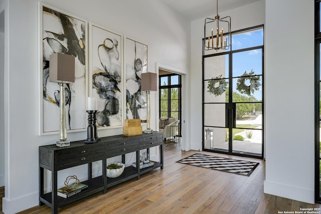121 Greystone Pt, Boerne, TX 78006 - entrance foyer featuring a chandelier, hardwood / wood-style floors, a high ceiling, and baseboards