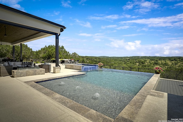 121 Greystone Pt, Boerne, TX 78006 - view of swimming pool with outdoor lounge area, a forest view, a patio, a ceiling fan, and a pool with connected hot tub