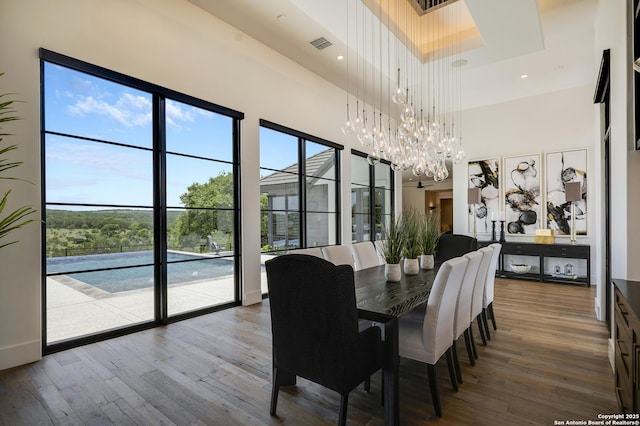 121 Greystone Pt, Boerne, TX 78006 - dining area featuring a towering ceiling, a chandelier, wood finished floors, and plenty of natural light