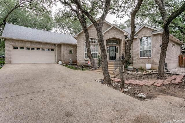18210 Crystal Ridge Dr, San Antonio, TX 78259 - view of front of home with driveway, brick siding, an attached garage, and roof with shingles