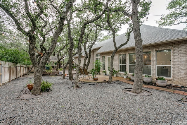 18210 Crystal Ridge Dr, San Antonio, TX 78259 - rear view of property featuring a shingled roof, a patio area, a fenced backyard, and brick siding