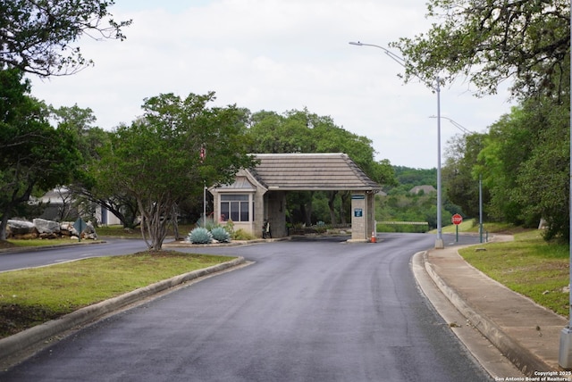 18210 Crystal Ridge Dr, San Antonio, TX 78259 - view of asphalt road featuring traffic signs, curbs, street lighting, and sidewalks