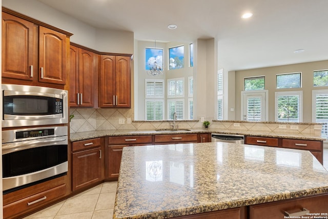 27711 Woodway Bnd, Boerne, TX 78006 - kitchen featuring appliances with stainless steel finishes, decorative backsplash, light stone countertops, a center island, and recessed lighting