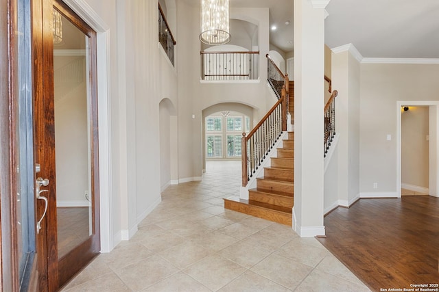 27711 Woodway Bnd, Boerne, TX 78006 - foyer with a chandelier, stairway, light tile patterned floors, ornamental molding, and arched walkways