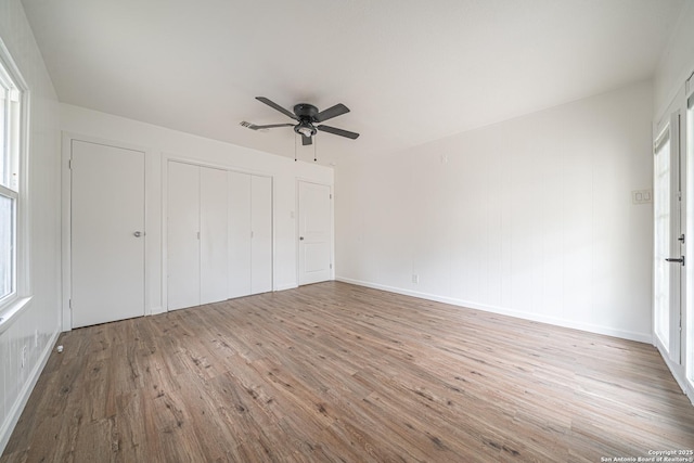 2310 W Houston St, San Antonio, TX 78207 - unfurnished bedroom featuring wood finished floors, a closet, a ceiling fan, and baseboards