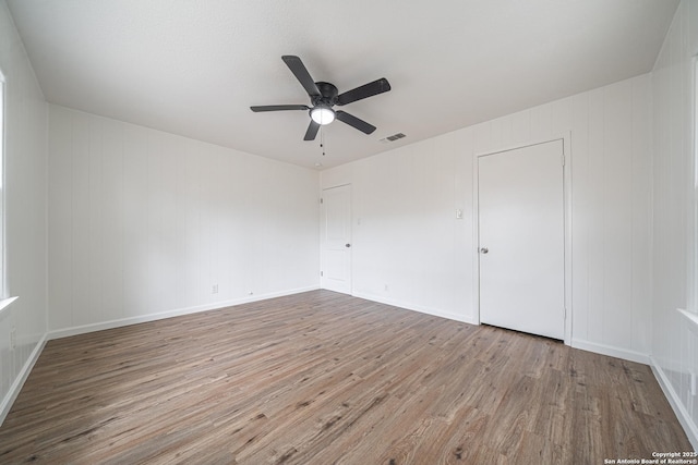 2310 W Houston St, San Antonio, TX 78207 - unfurnished bedroom with wood finished floors, a ceiling fan, and baseboards