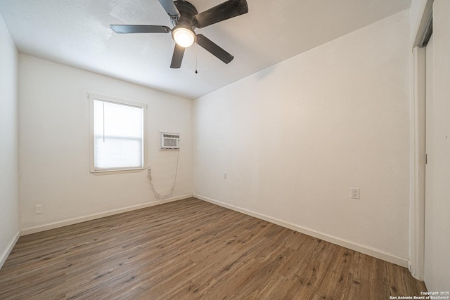 2310 W Houston St, San Antonio, TX 78207 - empty room with wood finished floors, baseboards, and a wall mounted air conditioner