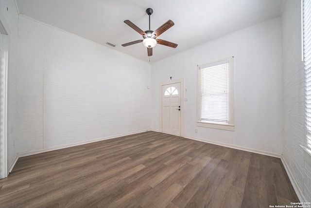 2310 W Houston St, San Antonio, TX 78207 - entrance foyer featuring dark wood-type flooring, a ceiling fan, brick wall, ornamental molding, and baseboards