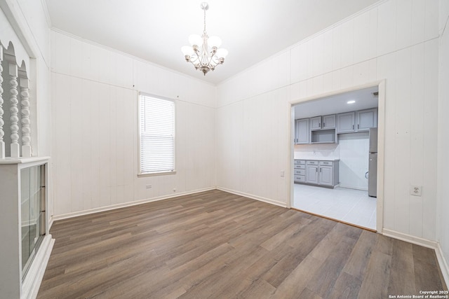 2310 W Houston St, San Antonio, TX 78207 - unfurnished living room with a chandelier, wood finished floors, ornamental molding, and baseboards