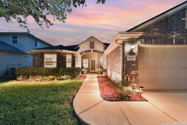 5327 Gemsbuck Chase, San Antonio, TX 78251 - view of front of house with brick siding, stone siding, an attached garage, and central AC unit