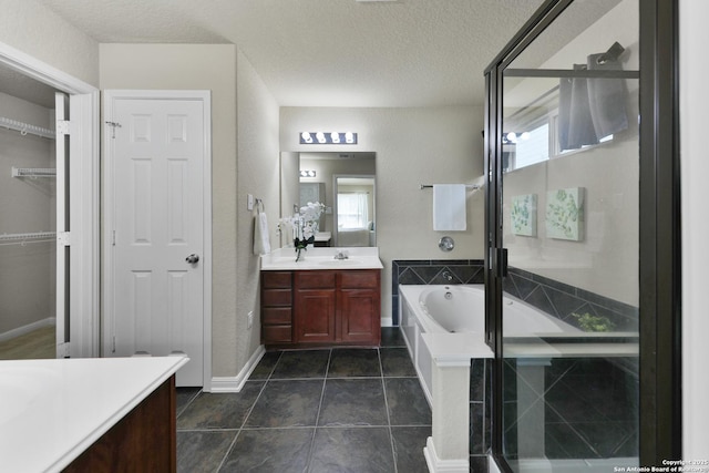 5327 Gemsbuck Chase, San Antonio, TX 78251 - full bathroom with vanity, a garden tub, a shower stall, a textured ceiling, and a spacious closet