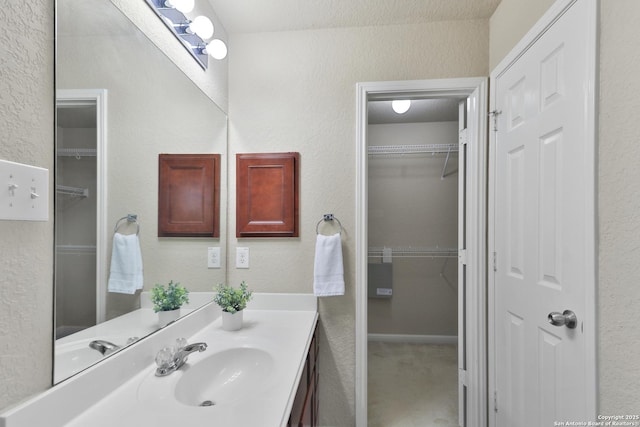 5327 Gemsbuck Chase, San Antonio, TX 78251 - bathroom featuring a textured wall, vanity, and a walk in closet