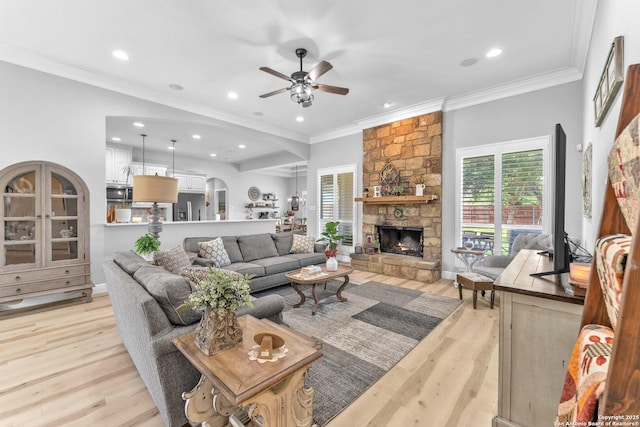 1216 Windy Dawn, Seguin, TX 78155 - living area with light wood-style flooring, a ceiling fan, a stone fireplace, ornamental molding, and recessed lighting