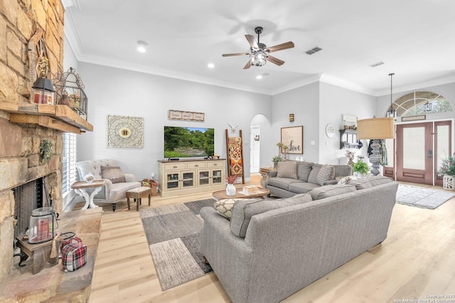 1216 Windy Dawn, Seguin, TX 78155 - living area with arched walkways, light wood-style floors, a ceiling fan, recessed lighting, and a stone fireplace