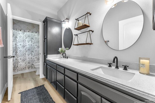 1216 Windy Dawn, Seguin, TX 78155 - full bathroom featuring double vanity, toilet, a shower with curtain, and wood finished floors