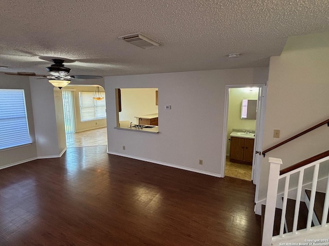 7835 Ruby Mdw, San Antonio, TX 78251 - unfurnished living room with wood finished floors, a sink, ceiling fan, a textured ceiling, and baseboards