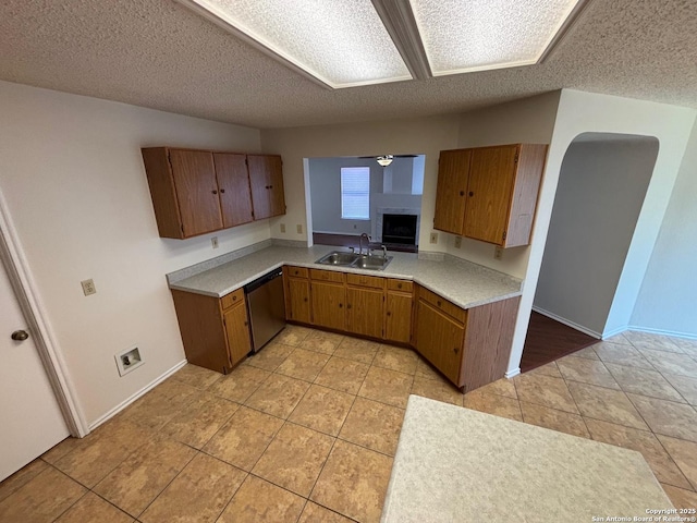 7835 Ruby Mdw, San Antonio, TX 78251 - kitchen featuring dishwasher, a sink, light countertops, brown cabinetry, and light tile patterned floors