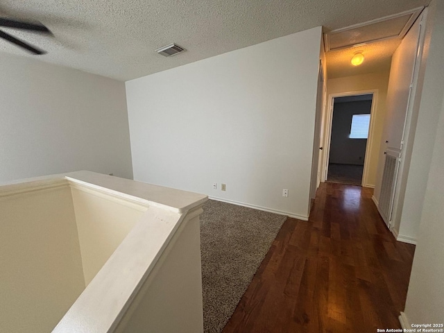 7835 Ruby Mdw, San Antonio, TX 78251 - hall featuring wood finished floors, a textured ceiling, an upstairs landing, and baseboards