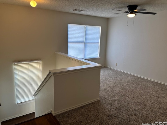 7835 Ruby Mdw, San Antonio, TX 78251 - spare room featuring ceiling fan, a textured ceiling, and dark colored carpet