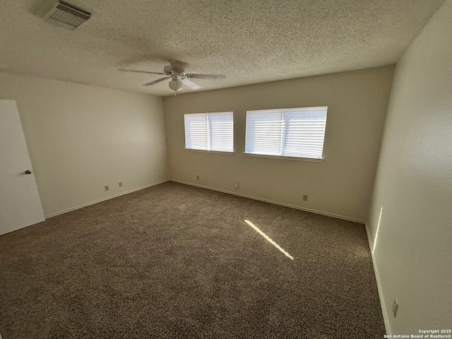 7835 Ruby Mdw, San Antonio, TX 78251 - spare room featuring a ceiling fan, a textured ceiling, and dark colored carpet