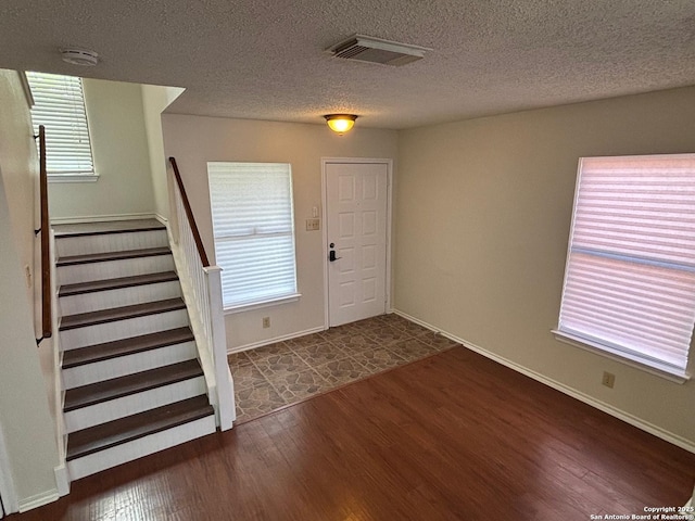 7835 Ruby Mdw, San Antonio, TX 78251 - foyer featuring dark wood-style floors, stairway, a textured ceiling, and baseboards