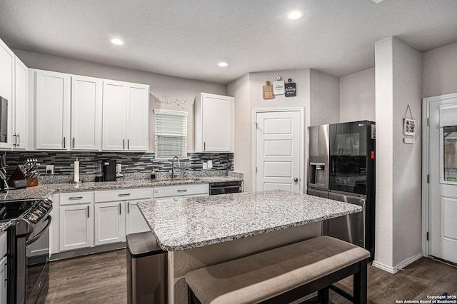 7129 Pisces, Converse, TX 78109 - kitchen with stainless steel fridge, a sink, gas stove, dark wood-style floors, and tasteful backsplash