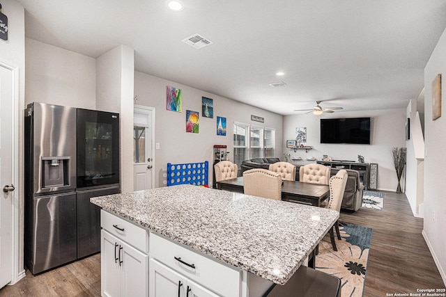 7129 Pisces, Converse, TX 78109 - kitchen featuring stainless steel fridge, ceiling fan, light stone counters, open floor plan, and white cabinets