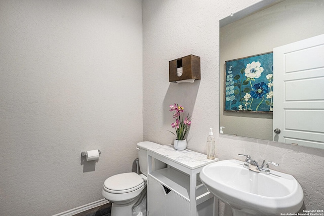 7129 Pisces, Converse, TX 78109 - half bath featuring a sink, toilet, and a textured wall