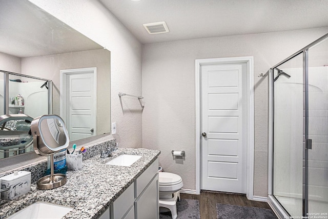 7129 Pisces, Converse, TX 78109 - full bathroom featuring wood finished floors, a shower stall, double vanity, toilet, and baseboards