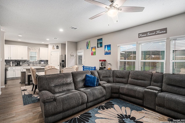 7129 Pisces, Converse, TX 78109 - living area with wood finished floors, a textured ceiling, healthy amount of natural light, a ceiling fan, and recessed lighting