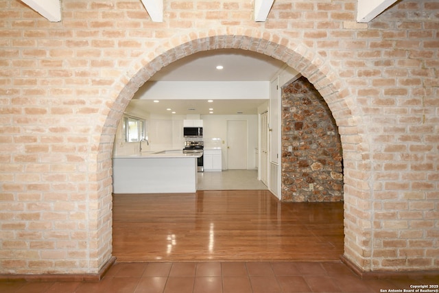 5803 Hollyhock, San Antonio, TX 78240 - kitchen with stainless steel appliances, light tile patterned floors, white cabinetry, light countertops, and arched walkways