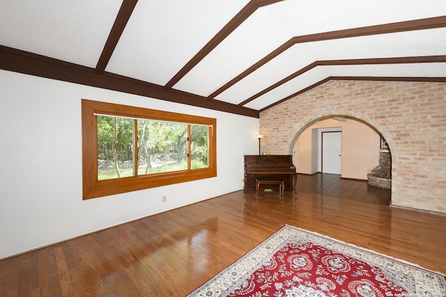 5803 Hollyhock, San Antonio, TX 78240 - unfurnished living room with arched walkways, wood finished floors, and brick wall