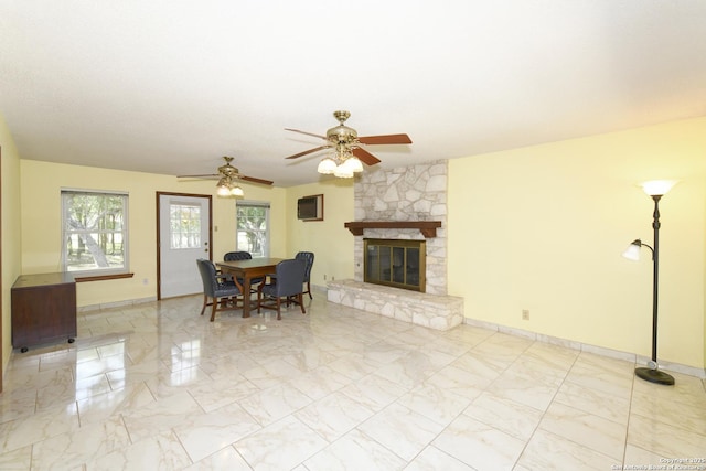 5803 Hollyhock, San Antonio, TX 78240 - living room with ceiling fan, marble finish floors, a stone fireplace, an AC wall unit, and baseboards