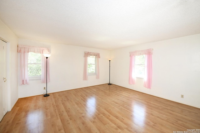 5803 Hollyhock, San Antonio, TX 78240 - unfurnished room with light wood finished floors, plenty of natural light, and a textured ceiling
