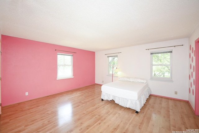5803 Hollyhock, San Antonio, TX 78240 - bedroom with light wood finished floors and a textured ceiling