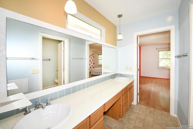 5803 Hollyhock, San Antonio, TX 78240 - ensuite bathroom with toilet, double vanity, and baseboards