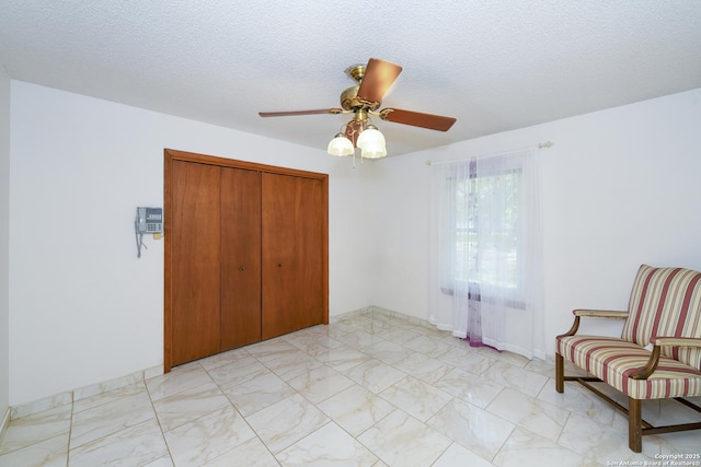 5803 Hollyhock, San Antonio, TX 78240 - unfurnished bedroom with light marble finish floors, a closet, ceiling fan, and a textured ceiling