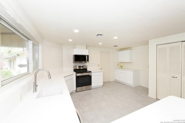 5803 Hollyhock, San Antonio, TX 78240 - kitchen featuring appliances with stainless steel finishes, a sink, white cabinets, recessed lighting, and light countertops