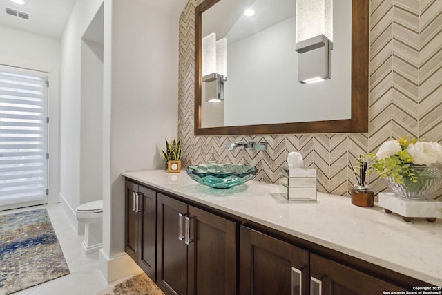 23510 Avila, San Antonio, TX 78255 - bathroom featuring decorative backsplash, vanity, toilet, and tile patterned flooring