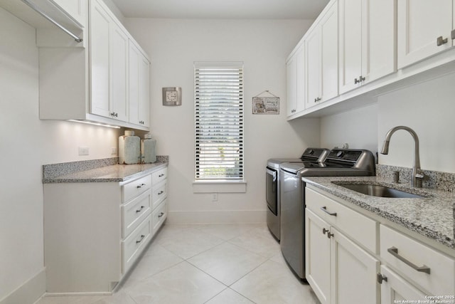 23510 Avila, San Antonio, TX 78255 - laundry room with washing machine and clothes dryer, cabinet space, baseboards, and light tile patterned floors