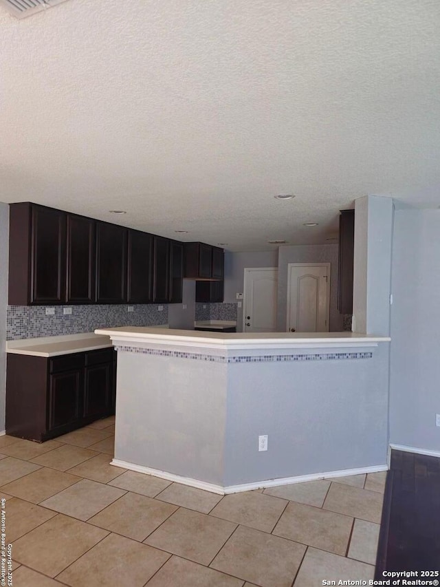8815 Adhinger, San Antonio, TX 78245 - kitchen with light countertops, decorative backsplash, a textured ceiling, and light tile patterned flooring