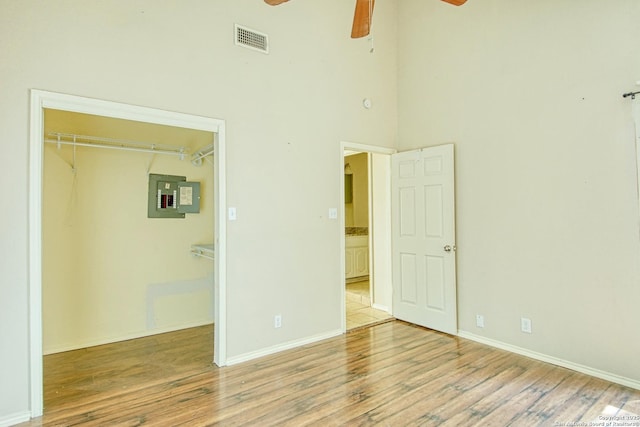 15018 Miss Ellie Dr, San Antonio, TX 78247 - unfurnished bedroom featuring electric panel, wood finished floors, a closet, baseboards, and a high ceiling