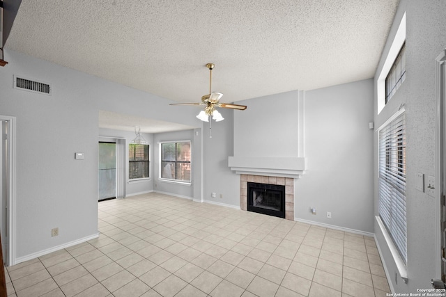 9387 Village Lance, San Antonio, TX 78250 - unfurnished living room with ceiling fan, a tile fireplace, a textured ceiling, light tile patterned floors, and baseboards