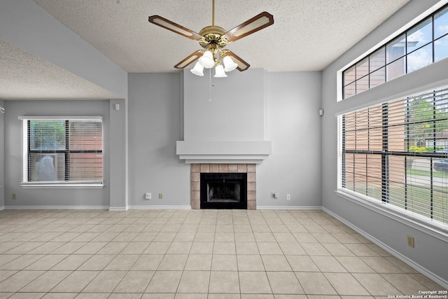 9387 Village Lance, San Antonio, TX 78250 - unfurnished living room featuring a textured ceiling, ceiling fan, plenty of natural light, a fireplace, and baseboards