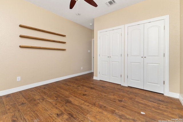 22919 Hightop, Elmendorf, TX 78112 - unfurnished bedroom featuring multiple closets, dark wood-type flooring, baseboards, and ceiling fan