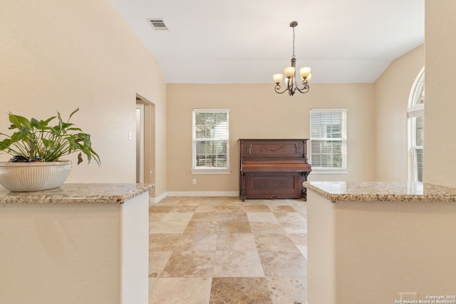 22919 Hightop, Elmendorf, TX 78112 - kitchen with a chandelier, plenty of natural light, decorative light fixtures, light stone counters, and lofted ceiling