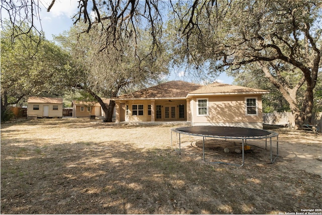 22919 Hightop, Elmendorf, TX 78112 - back of property with a trampoline and ceiling fan