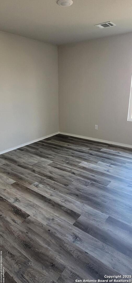 10814 Prusiner, Converse, TX 78109 - empty room featuring dark wood-type flooring and baseboards